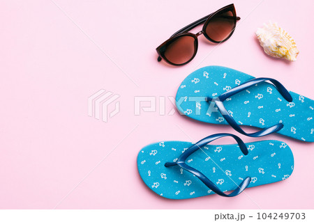 Summer travel concept. Flip flops, sunglasses and starfish on white. Top view on colored background Summer travel concept. Flip flops, sunglasses and starfish on white. Top view on colored background 104249703