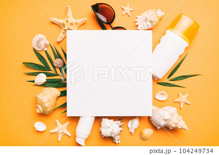 Summer time concept with blank greeting card and blank white paper on colored background. Seashells from ocean shore in the shape of frame separated with space for text top view Summer time concept with blank greeting card and blank white paper on colored background. Seashells from ocean shore in the shape of frame separated with space for text top view 104249734