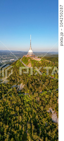 Sunny evening at Jested Mountain with unique building on the summit. Liberec, Czech Republic. Aerial view from drone. 104250287