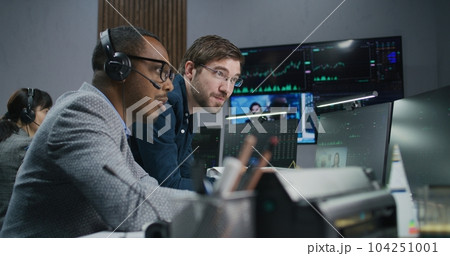Mixed race stock traders talk and monitor real-time stocks data 104251001