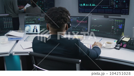 African American trader analyzes market charts African American trader analyzes market charts 104251028