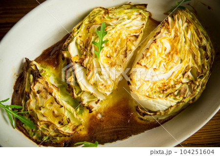 Young early cabbage baked in pieces in the oven Young early cabbage baked in pieces in the oven 104251604