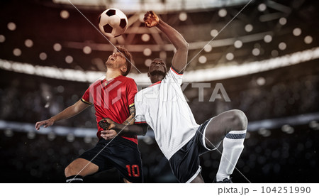 Football action with competing soccer players jumping to hit the ball with head 104251990