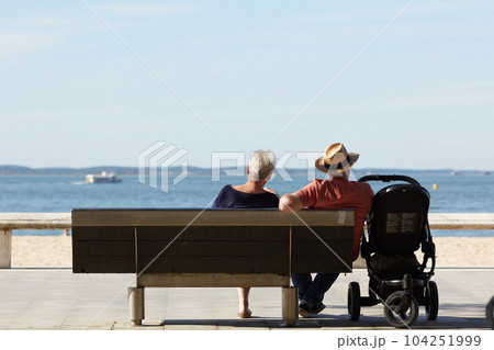 senior couple sitting on a bench looking at the sea senior couple sitting on a bench looking at the sea 104251999