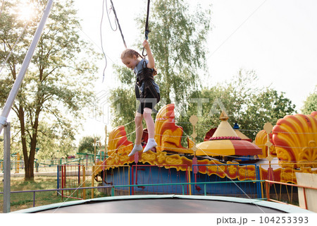 Happy schoolgirl having fun at an adventure park on a summer day. High quality photo 104253393