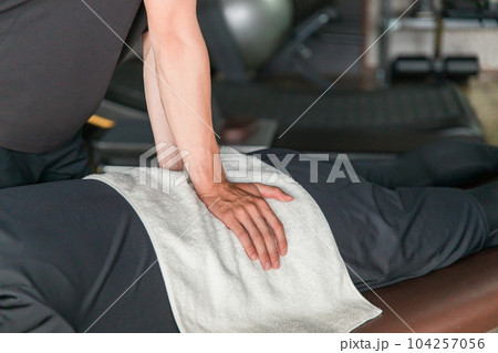 スポーツ整体を受ける男性と施術するメディカルトレーナー・柔道整復師（腰） 104257056
