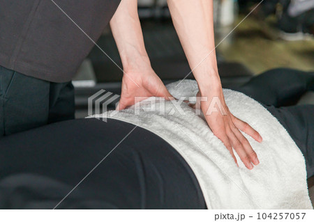 スポーツ整体を受ける男性と施術するメディカルトレーナー・柔道整復師（腰） 104257057