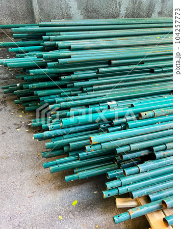 turquoise pipes stacked on the ground. High quality photo 104257773