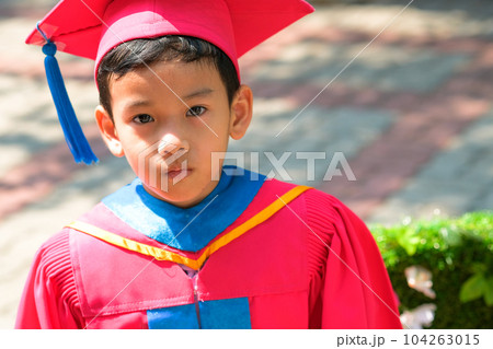 Close-up image portrait of a Asian boy on graduating from kindergarten, he is wearing graduation cap and gown. Education Concept. 104263015