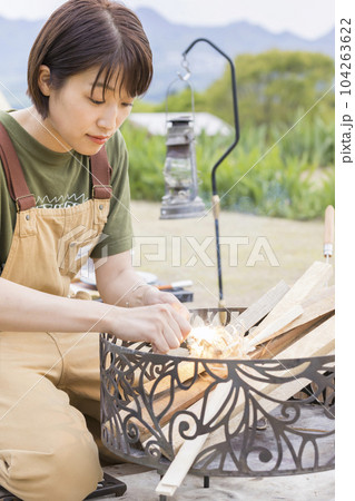 ファイヤースターターで火をつける若い女性 104263622