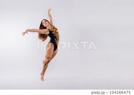 Full length portrait of plump woman doing physical exercise, jumping, white and black background. 104266475
