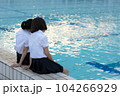 夕暮れのプールサイドで肩を寄せ合う女子高生 104266929