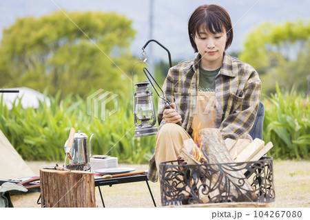 火ばさみを持って焚火の日の様子を見る若い女性 焚火 アウトドア ソロキャンプ 火ばさみを持って焚火の日の様子を見る若い女性 焚火 アウトドア ソロキャンプ 104267080