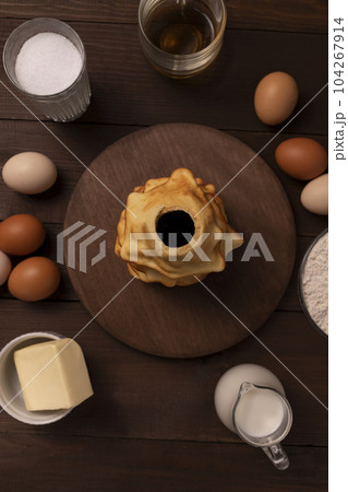 Top view of ingredients for baking baumkuchen, sakotis ,sekacz on wooden table, traditional spit cake of lithuanian, polish, german,belarusian cuisine made of butter,eggs,flour,sugar. Vertical plane. 104267914