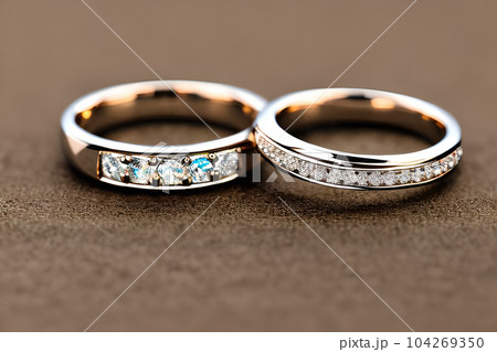 Captivating close up shot of two wedding rings, delicately intertwined to symbolize the everlasting bond of love and commitment. Jewelry gold diamond ring for anniversary, valentine, or engagement. Captivating close up shot of two wedding rings, delicately intertwined to symbolize the everlasting bond of love and commitment. Jewelry gold diamond ring for anniversary, valentine, or engagement. 104269350