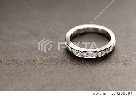 stunning close up shot of a single wedding rings, delicately intertwined to symbolize the everlasting bond of love and commitment. Jewelry gold diamond ring for anniversary, valentine, or engagement. 104269394