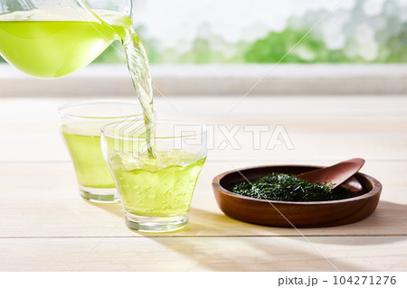 爽やかな光が差し込む部屋で二つのガラスコップにお茶を注ぐ 爽やかな光が差し込む部屋で二つのガラスコップにお茶を注ぐ 104271276