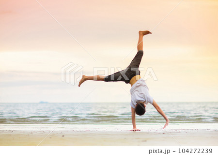 Teenager doing calisthenics exercise. Beach yoga. Teenager doing calisthenics exercise. Beach yoga. 104272239