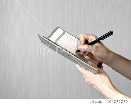 スケジュール帳にペンで書く手元 104273270
