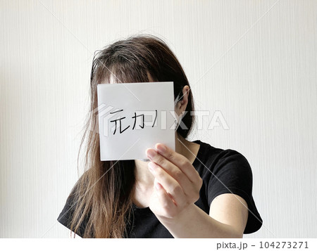 顔の前で元カノの文字入り紙を片手で持つ女性 顔の前で元カノの文字入り紙を片手で持つ女性 104273271