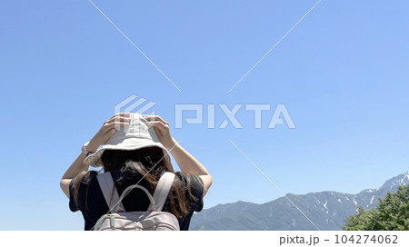 山並みの前で頭を抱える女性の後姿_ワイド 山並みの前で頭を抱える女性の後姿_ワイド 104274062