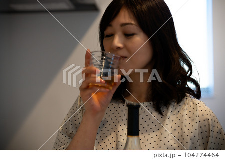キッチンでお酒を飲むミドルの女性 104274464