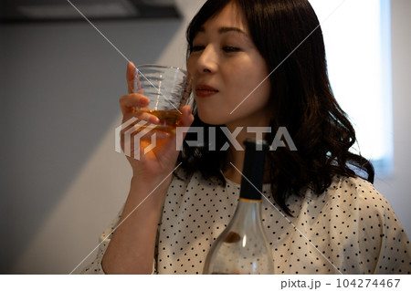 キッチンでお酒を飲むミドルの女性 104274467