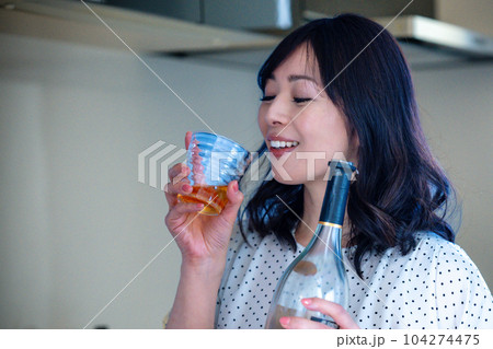 キッチンでお酒を飲むミドルの女性 104274475