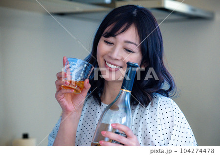 キッチンでお酒を飲むミドルの女性 104274478