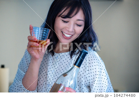 キッチンでお酒を飲むミドルの女性 104274480