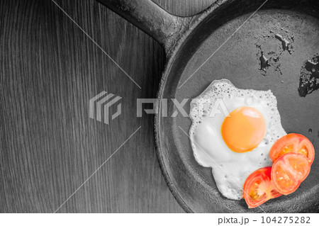 Egg, sunny side up, with fresh tomatoes in a frying pan Egg, sunny side up, with fresh tomatoes in a frying pan 104275282