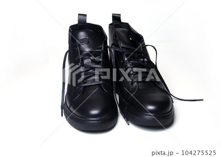 black leather men's shoes on a clean white background. These stylish ankle boots are crafted from high-quality leather. The closed-up shot showcases the fine details and craftsmanship. Out of focus 104275525