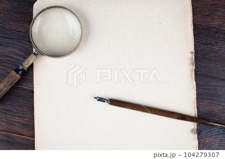 Antique vintage magnifying glass with old paper and ink feather pen Antique vintage magnifying glass with old paper and ink feather pen 104279307