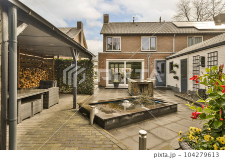 a backyard area with a fountain and fire pit in the middle, surrounded by brick paversed buildings on both sides a backyard area with a fountain and fire pit in the middle, surrounded by brick paversed buildings on both sides 104279613