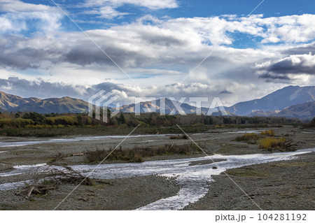 Photograph of a dry river running through a valley in New Zealand Photograph of a dry river running through a valley in New Zealand 104281192