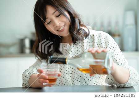 ダイニングテーブルで飲酒するミドルの女性 104281385