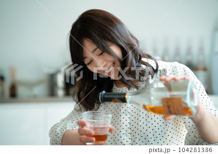 ダイニングテーブルで飲酒するミドルの女性 ダイニングテーブルで飲酒するミドルの女性 104281386