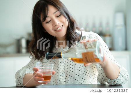 ダイニングテーブルで飲酒するミドルの女性 104281387