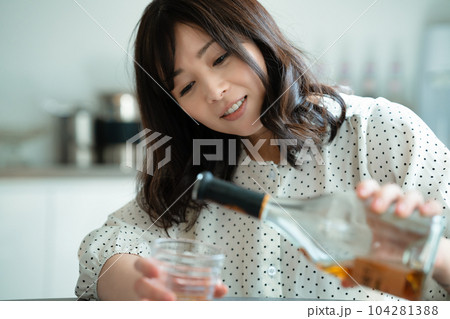 ダイニングテーブルで飲酒するミドルの女性 ダイニングテーブルで飲酒するミドルの女性 104281388