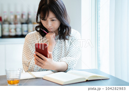 ダイニングテーブルで勉強するミドルの女性 104282983