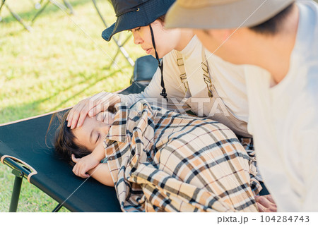 キャンプ場に来て遊び疲れてコットに眠る子供（体調不良・発熱） 104284743