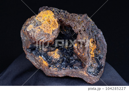 Goethite geode (hydrogoethite) in limonite on a black background, iron ore 104285227