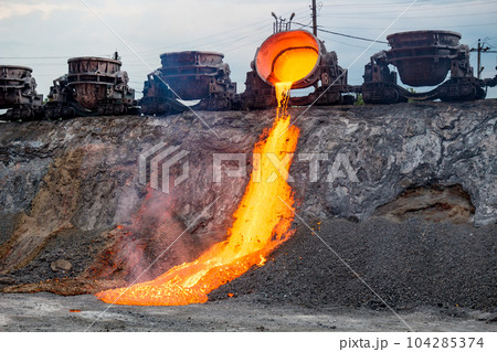 Colorful stream of molten metal at a steel mill. Blast furnace slag at the iron foundry 104285374