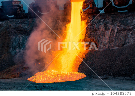 Colorful stream of molten metal at a steel mill. Blast furnace slag at the iron foundry Colorful stream of molten metal at a steel mill. Blast furnace slag at the iron foundry 104285375