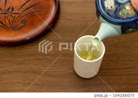 温かいお茶を急須からコップに注ぐ 温かいお茶を急須からコップに注ぐ 104286075
