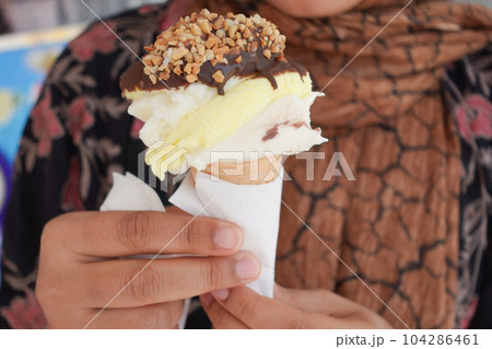 young women eating chocolate flavor ice cream young women eating chocolate flavor ice cream 104286461