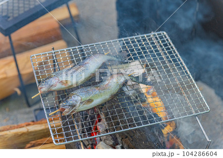 キャンプ場 ニジマス網焼き バーベキューイメージ素材  104286604