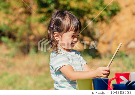キャンプ場に遊びにきておままごとをする女の子・子供（ファミリーキャンプ） 104288552