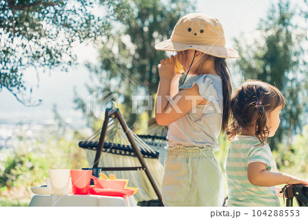 キャンプ場に遊びにきておままごとをする姉妹・女の子・子供(ファミリーキャンプ) キャンプ場に遊びにきておままごとをする姉妹・女の子・子供(ファミリーキャンプ) 104288553