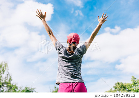 青空に向かって両手を広げるスポーツ中の女性 青空に向かって両手を広げるスポーツ中の女性 104289212